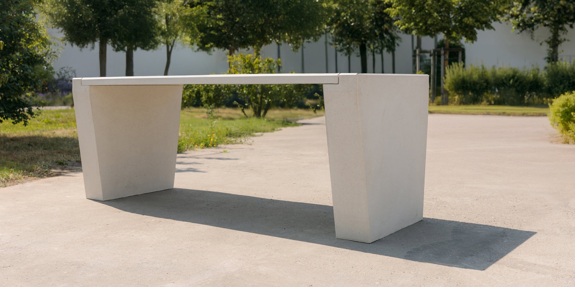 Outdoor-Betontisch aus hellgrauem Beton mit glatter Platte und zwei skulpturalen Beinen