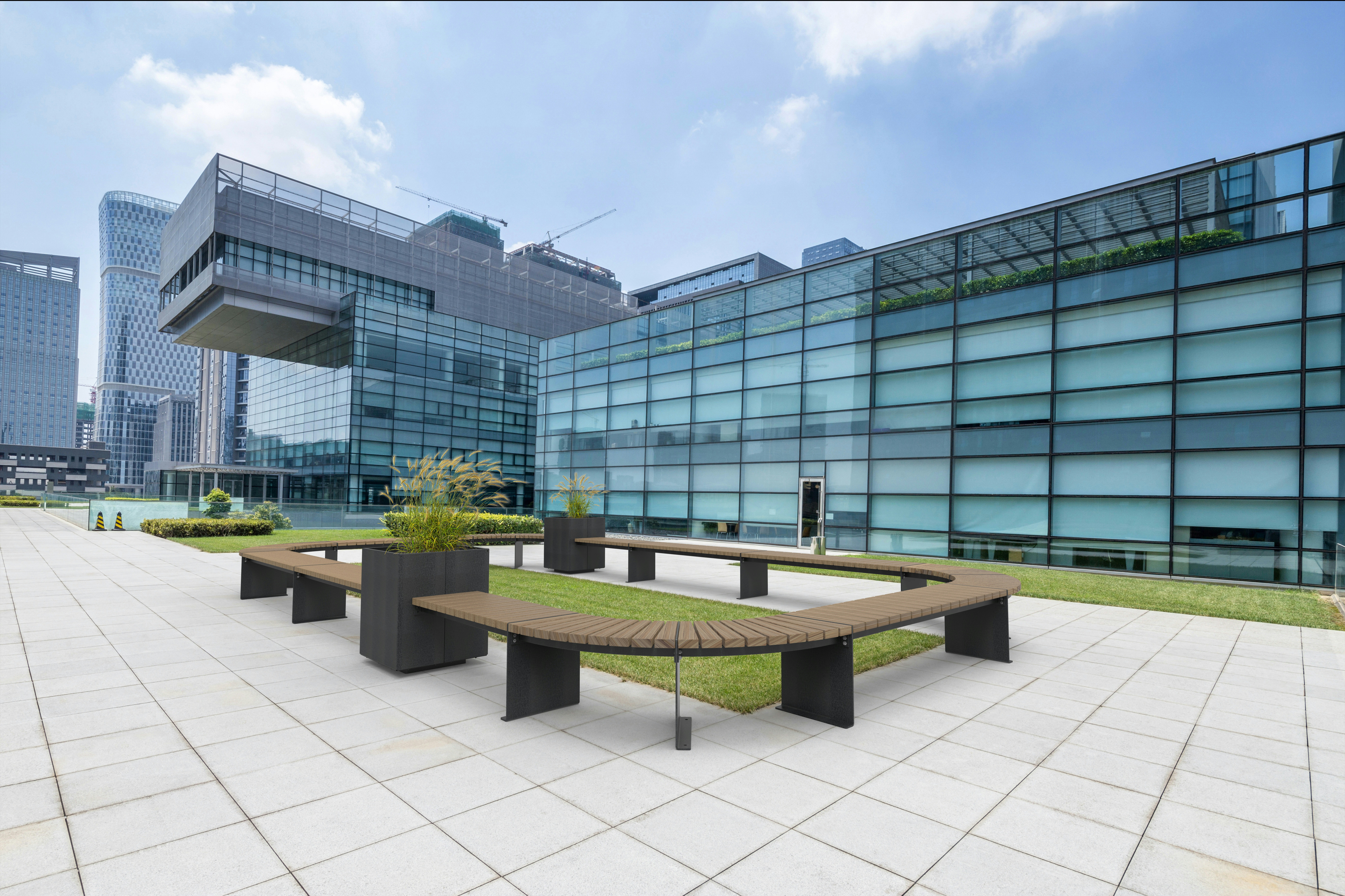 U-förmige Holzbank auf dunklem Metallgestell, Outdoor-Sitzbank vor Glasfassade